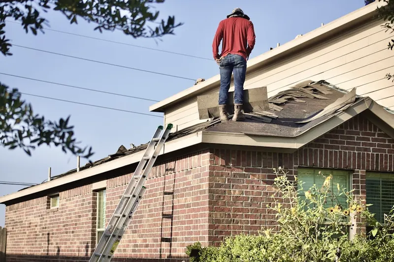 Professional roofer working on a residential roof in Plainfield Center